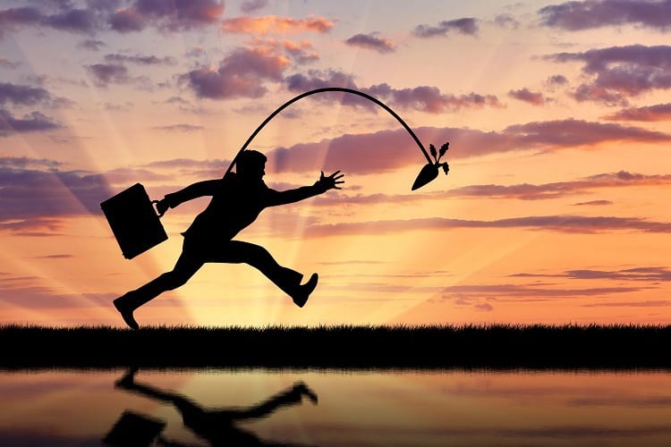 Silhouette of businessman running for the carrot and reflection in water.