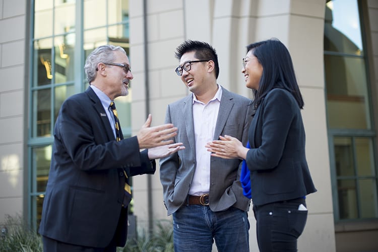 Dean Rich Lyons greets Kevin Chou, BS 02, and Connie Chen, naming donors for the Haas school's new academic building.