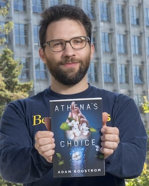 Adam Boostrom holds his book "Athena's Choice."