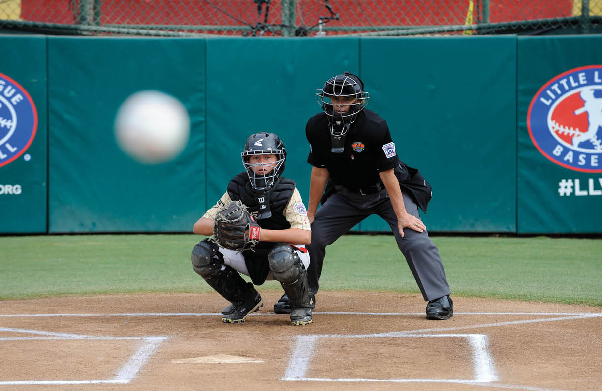Kate Hart watches an incoming pitch from behind home plate