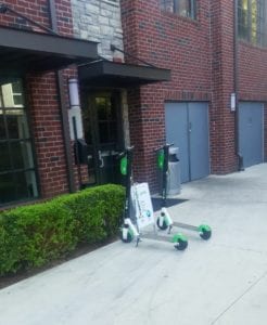 Two electric scooters parked outside residence.