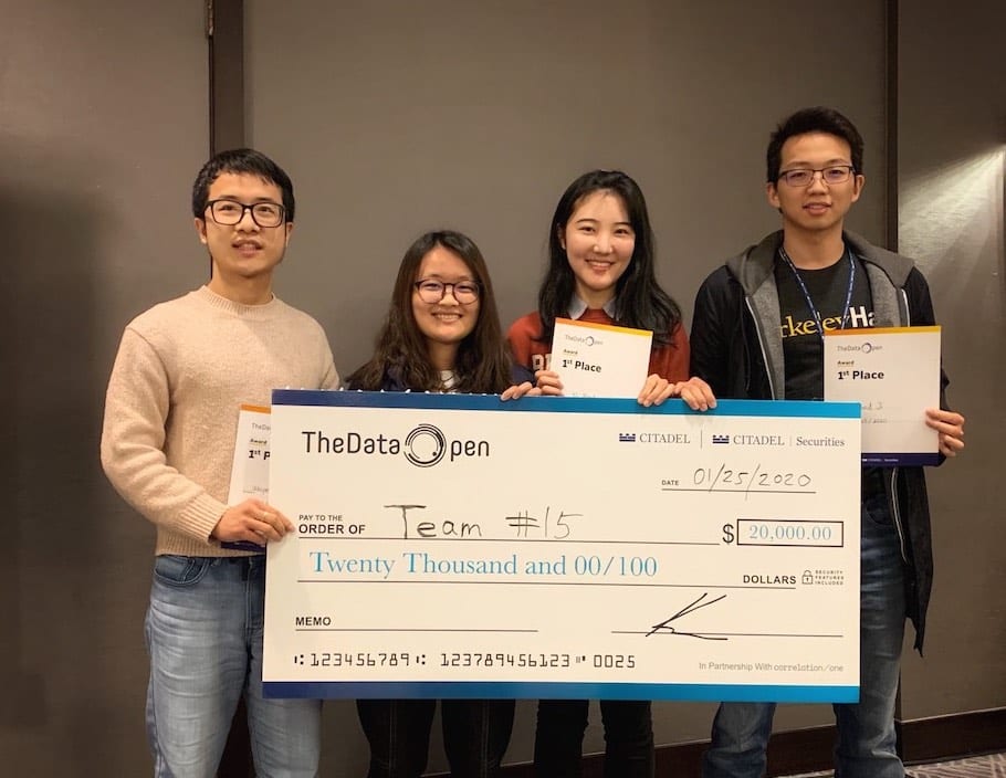 Four students holding a check.