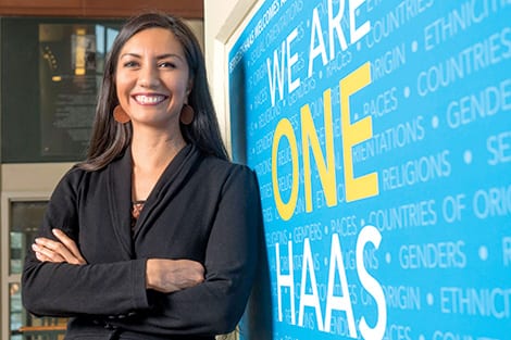 Woman standing next to sign that says we are one Haas