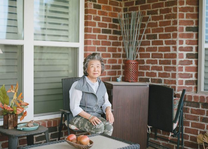 Frieda Quon, a retired librarian for the Mississippi Delta Chinese Heritage Museum, sits on her front porch.