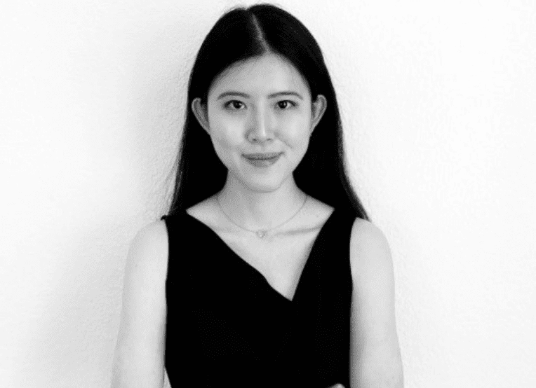 Black and white portrait of Asian woman with long hair. Dressed in black blouse.