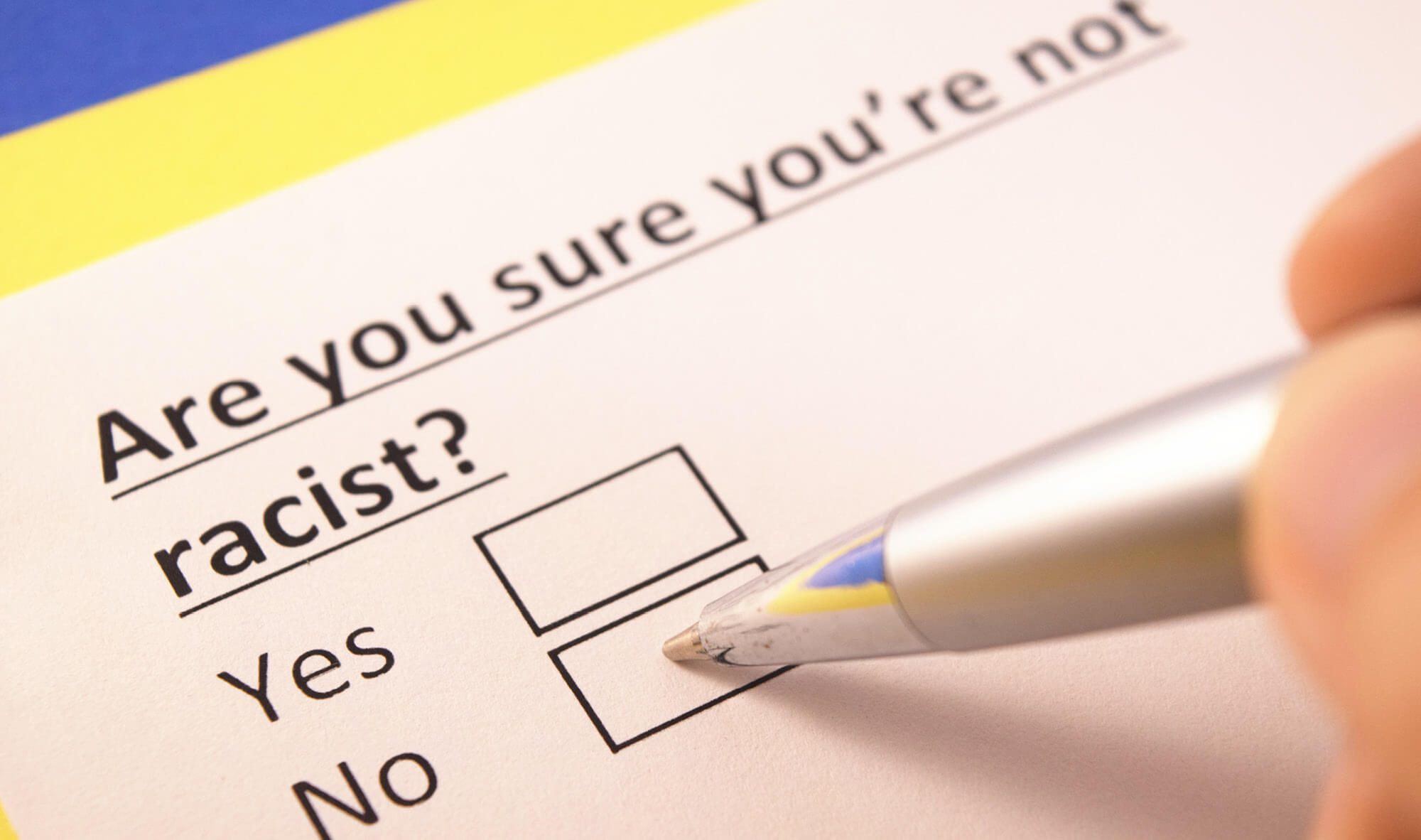 Survey with the question: Are you sure you're not racist? and yes/no boxes. A pen is poised to select "no."