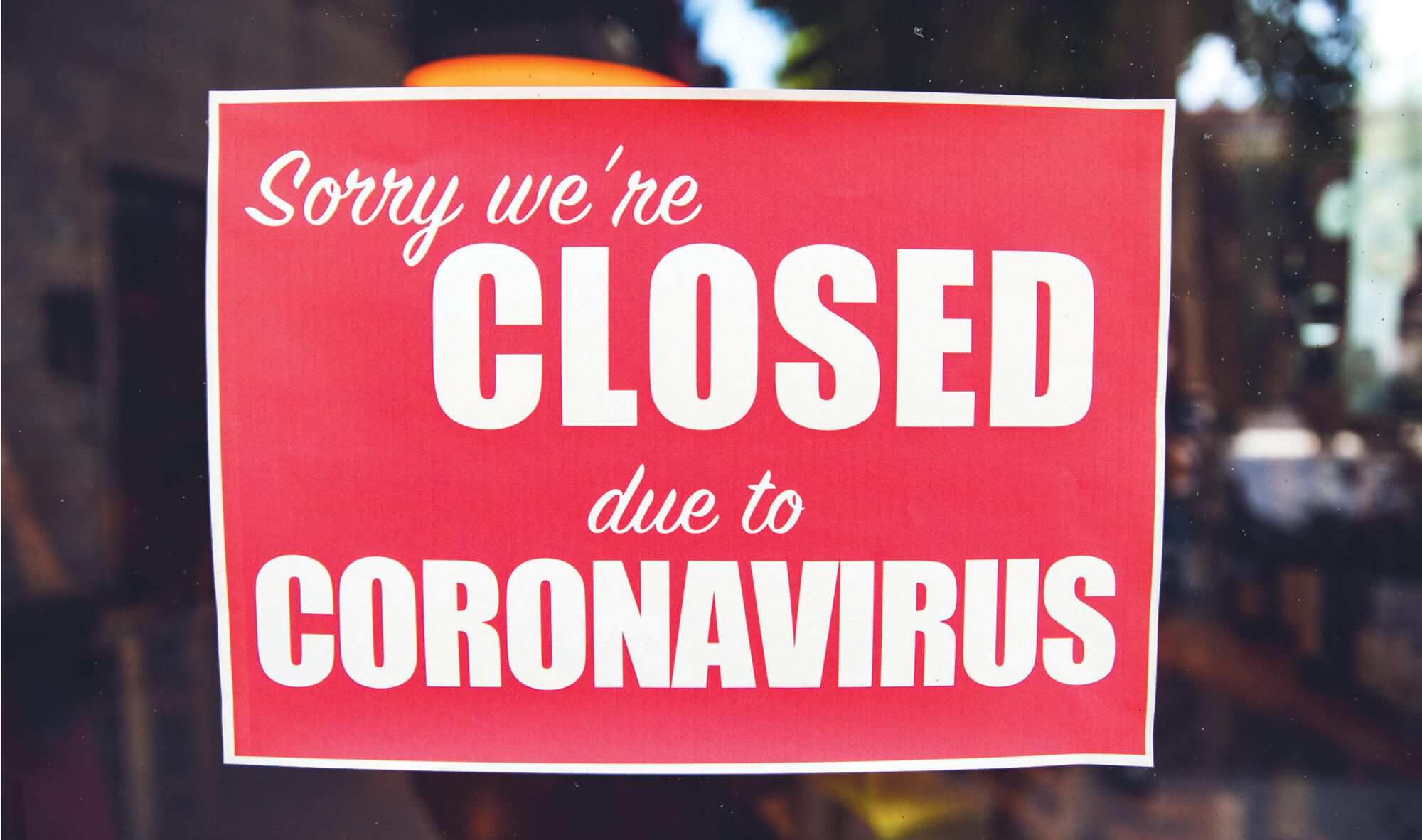 Sign on a window that says, "Sorry we're closed due to coronavirus."