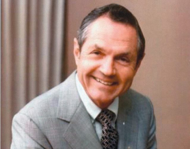 Head shot of Cornell C. Maier, smiling, in a suit and tie.