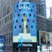 Scott Robertson, BCEMBA 14, in front of the Nasdaq sign bearing his company's name.