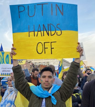 Fiodor Otero holding a sign at a rally for Ukraine in San Francisco City Hall.