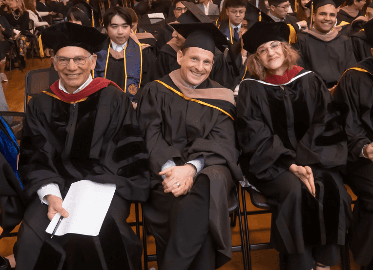 two men and one woman dressed in academic regalia