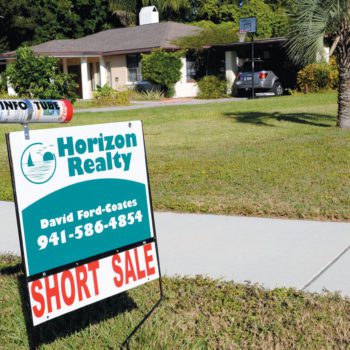 Sign in front of a house advertising a short sale.