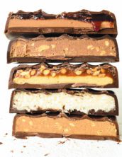 Cross-sections of five different Ocho candy bars stacked atop one another.