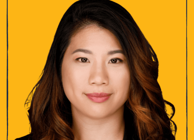 Asian woman with long curly hair. Yellow background