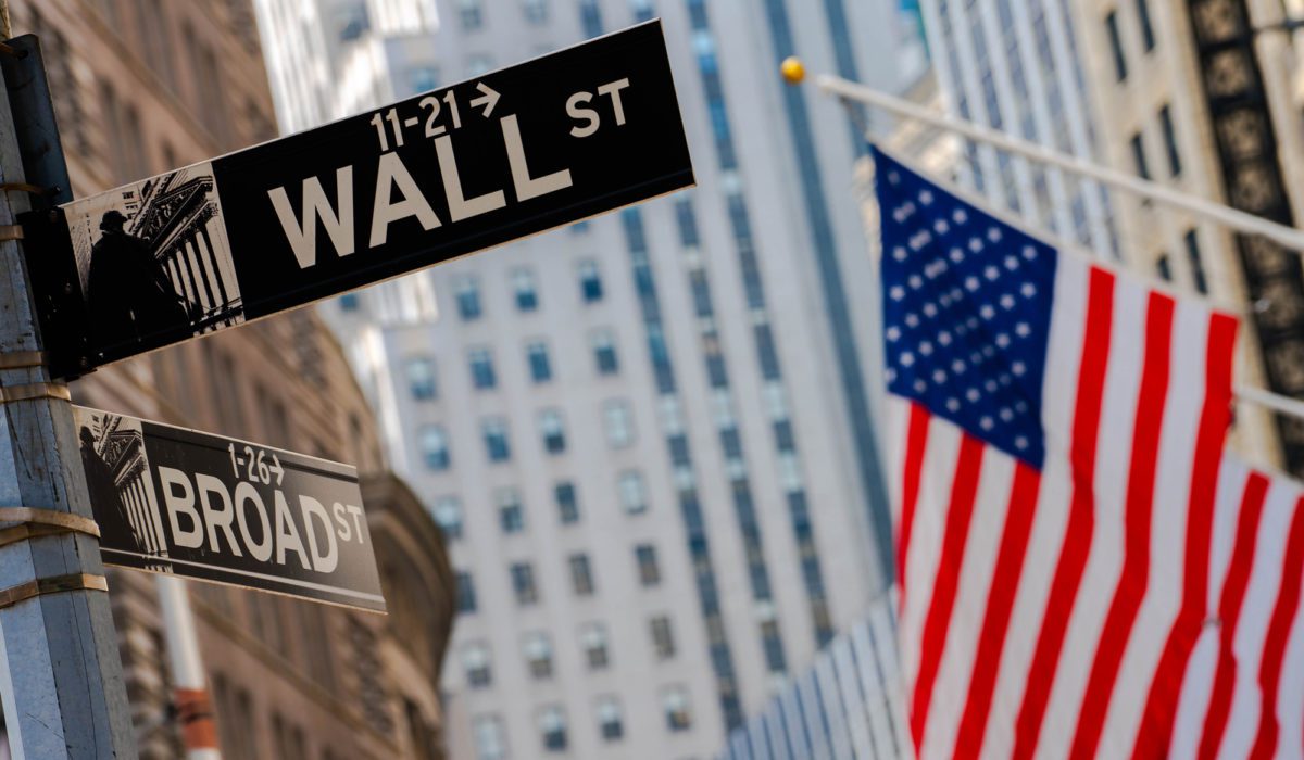 A Wall Street sign and American flag