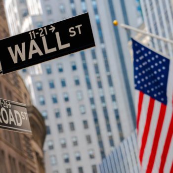 A Wall Street sign and American flag