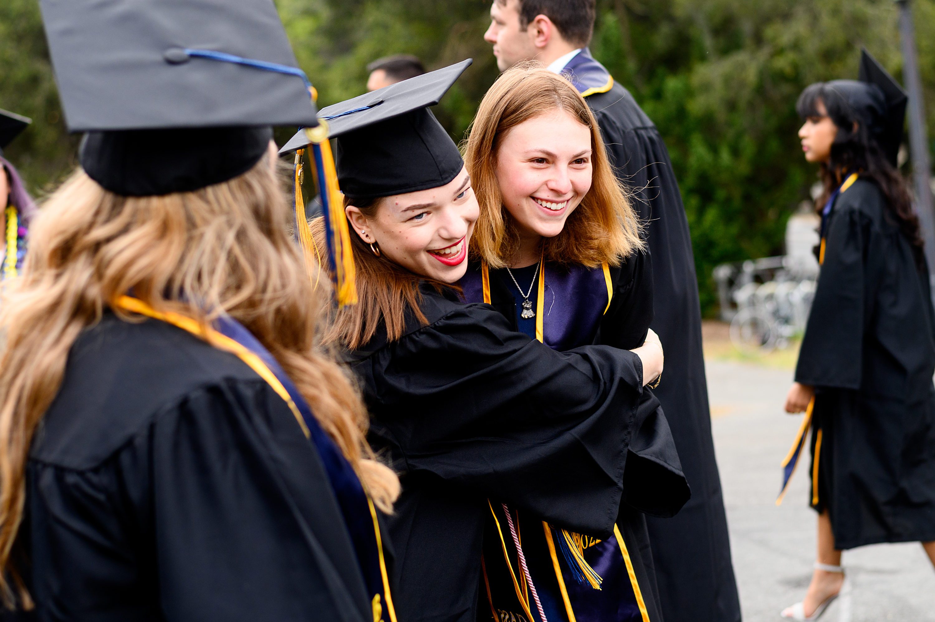 two students hugging at undergraduate commencement