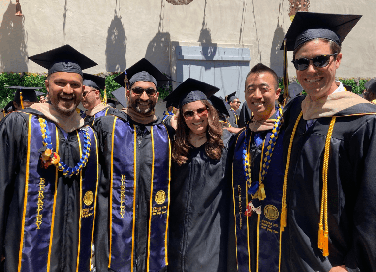 MBA students behind stage in cap and gowns at the Greek Theatre