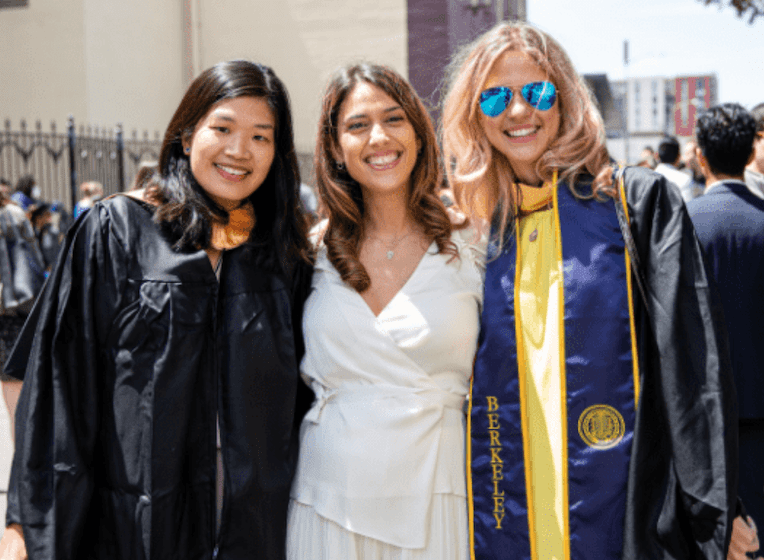 three female MBA grads at makeup commencement