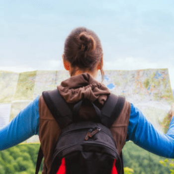women holding a map. She is in the outdoors and wearing a backpack