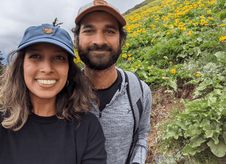 Woman and man on a hike. They take a moment to take a photo.
