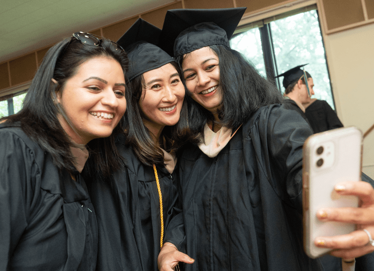 three female graduates take a selfie