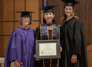 Three women donned in academic regalia