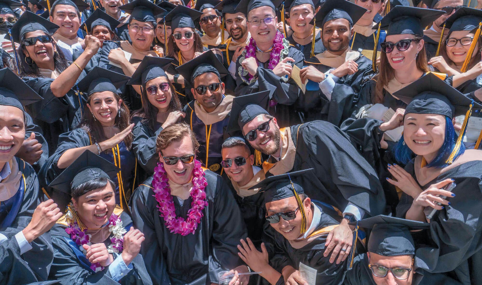 Large group of graduates in caps and gowns celebrating.