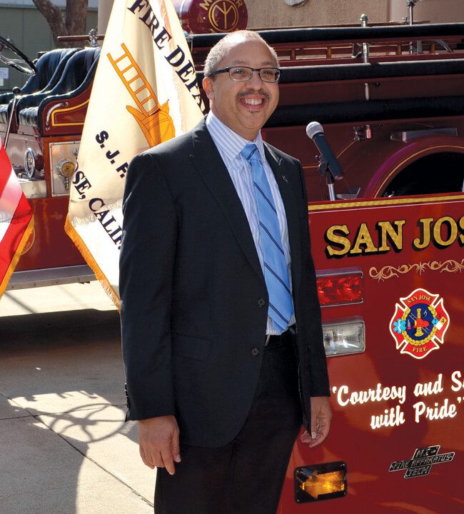 Man standing in front of a San Jose firetruck.