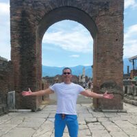 Chris Chan standing in front of an archway in Pompeii.