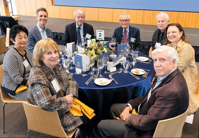 Eight people seated around a luncheon table.