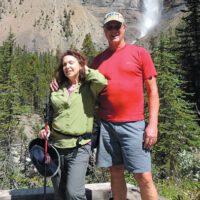 Tim Leach and his wife standing in front of a mountain in Canada while on a hike.