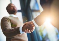 Closeup shot of two two men shaking hands in an office