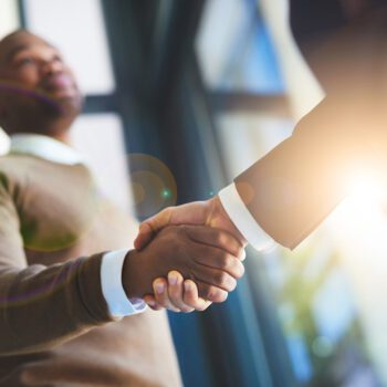 Closeup shot of two two men shaking hands in an office
