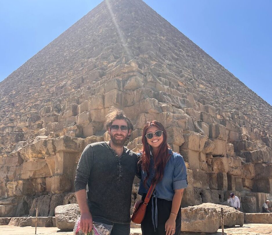 man and a woman standing in front of pyramid in Egypt
