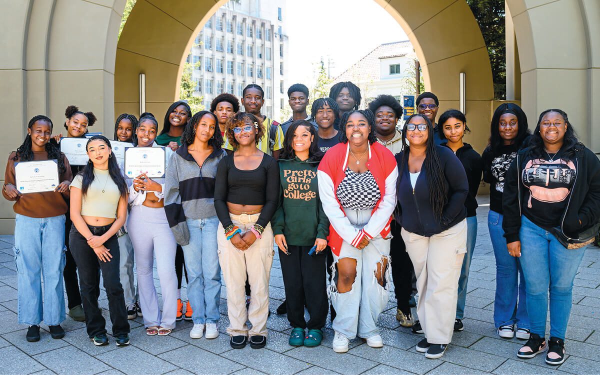 Group of Black teens, some holding completion certificates, who attended a financial education program at Berkeley Haas.