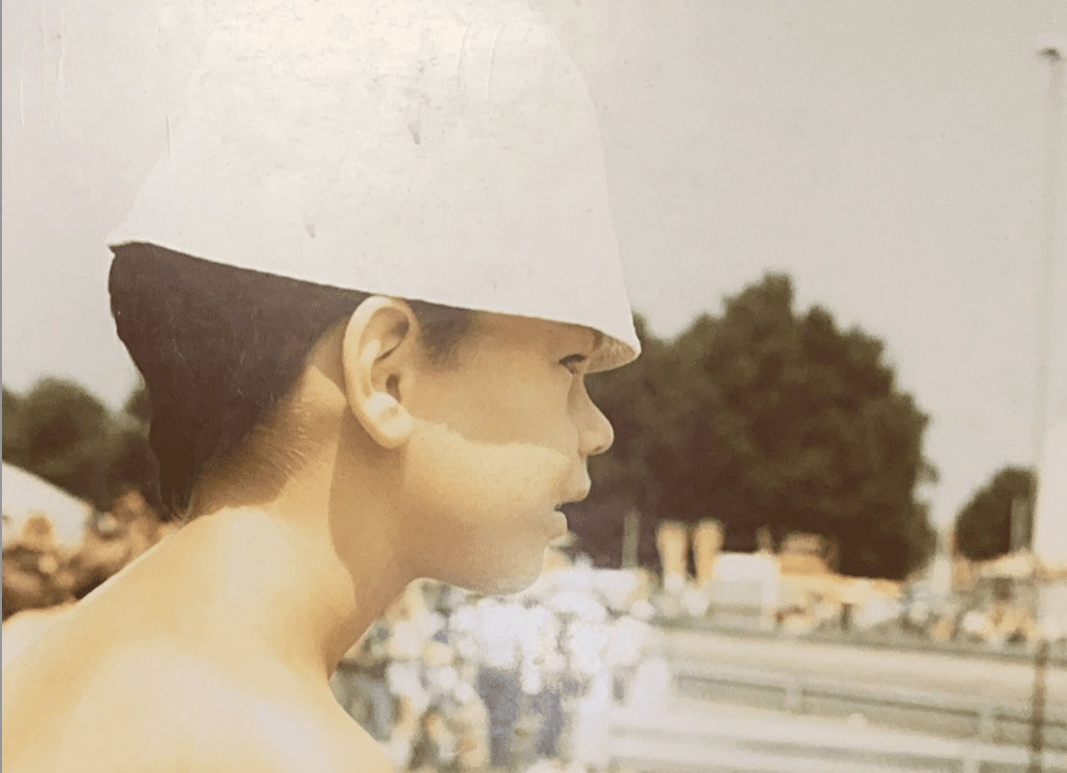 A young boy staring out at a car racing track.