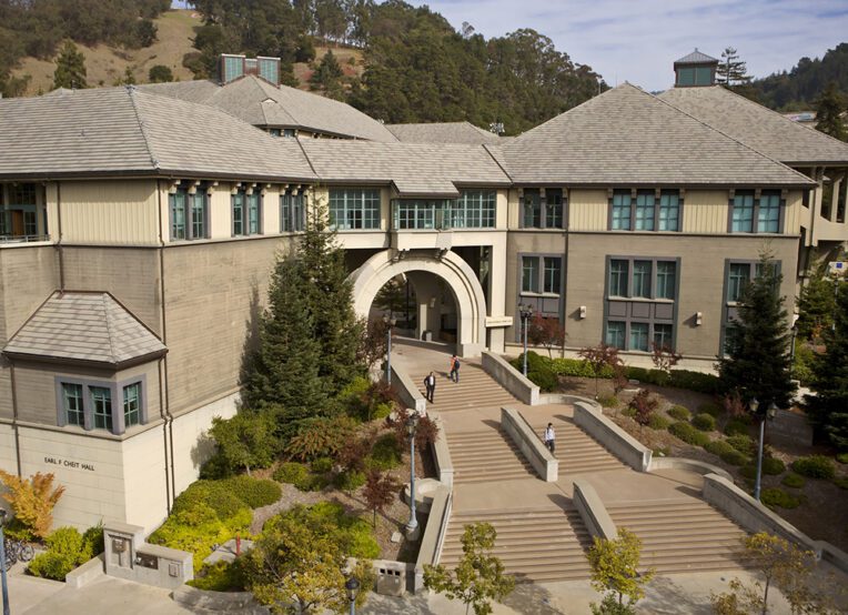 An aerial view of the Haas School of Business campus showing a wide staircase leading up to an arched entry between two buildings.