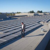 Chris Pawlik standing amid solar panels.