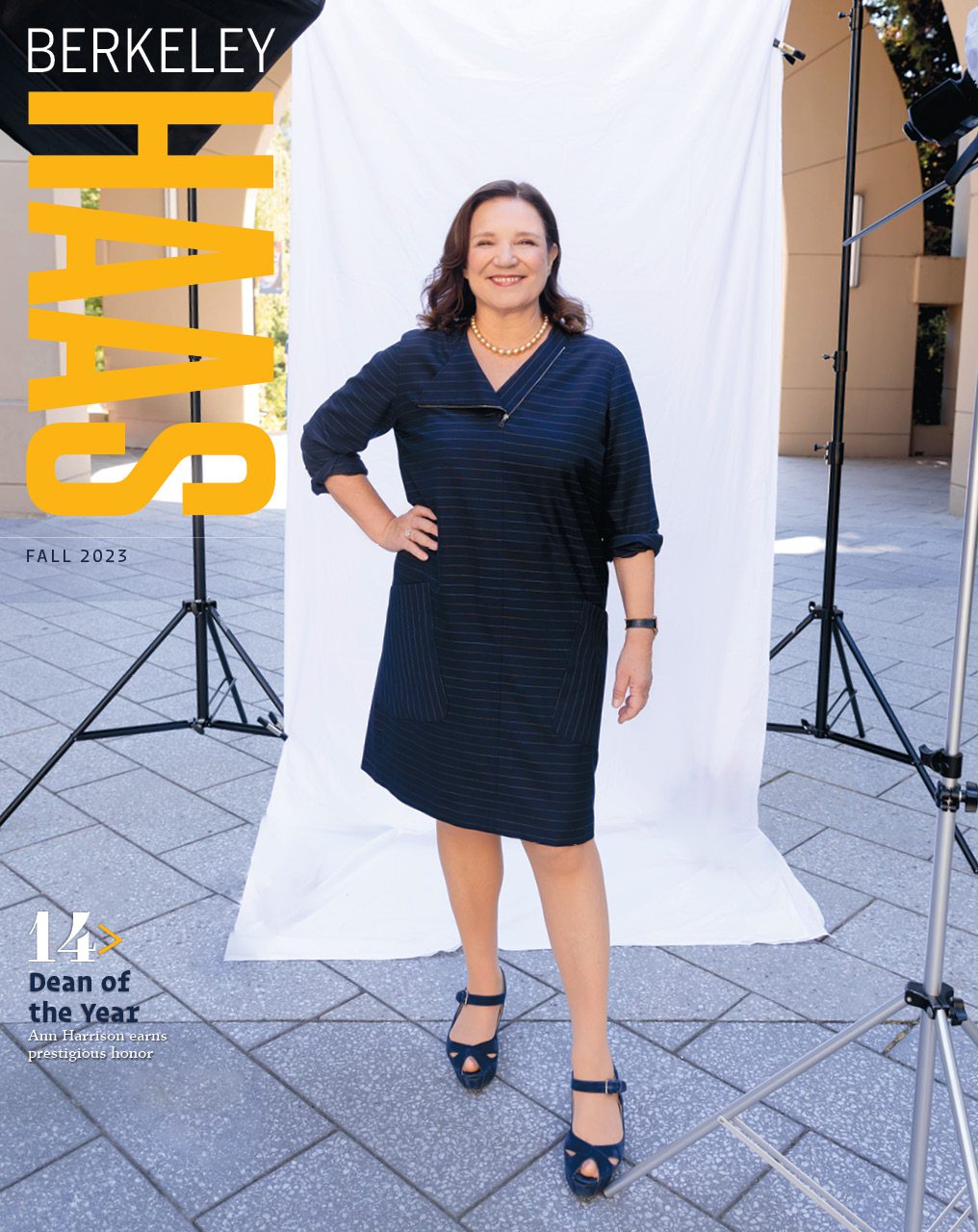 Magazine cover image of Dean Ann Harrison at an on-campus photo shoot with a white screen behind her.