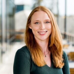 Photo of a woman with long red hair wearing green shirt