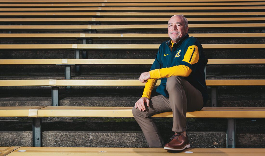 Man sitting on gold bleachers wearing a Cal shirt.