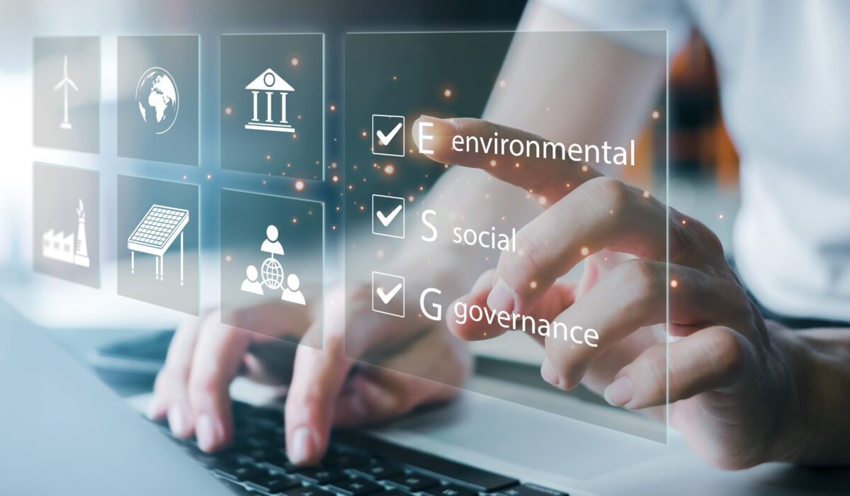 Photo illustration shows a woman's hands typing on laptop and pointing to a checklist labeled environmental, social, governance.