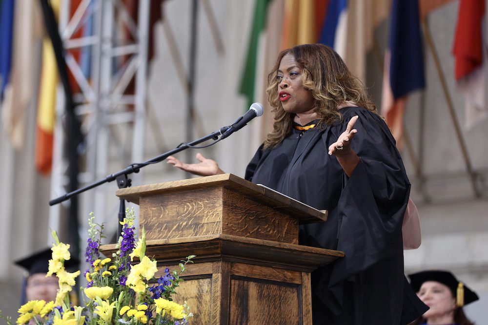 woman standing at the podium on stage at commencement