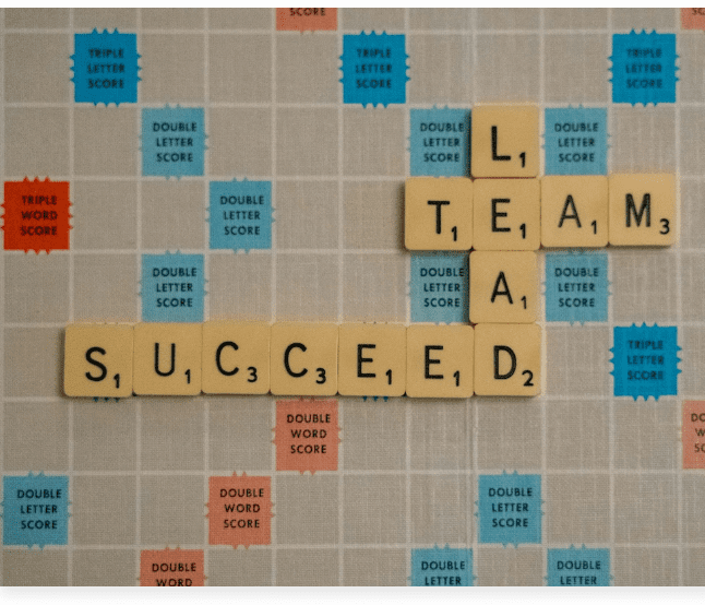 Picture of Scrabble gameboard with the words "succeed", "lead" and "team" spelled out.