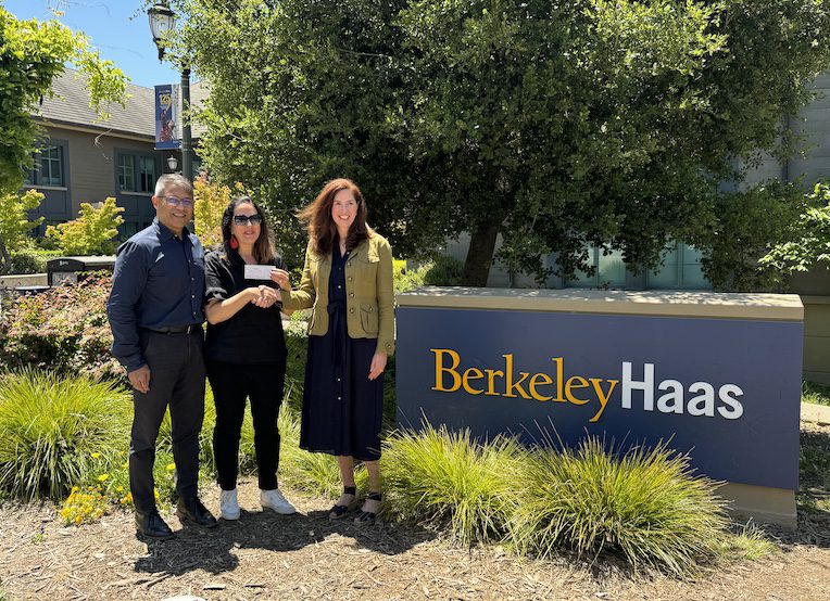 three people standing in front of the Berkeley Haas sign