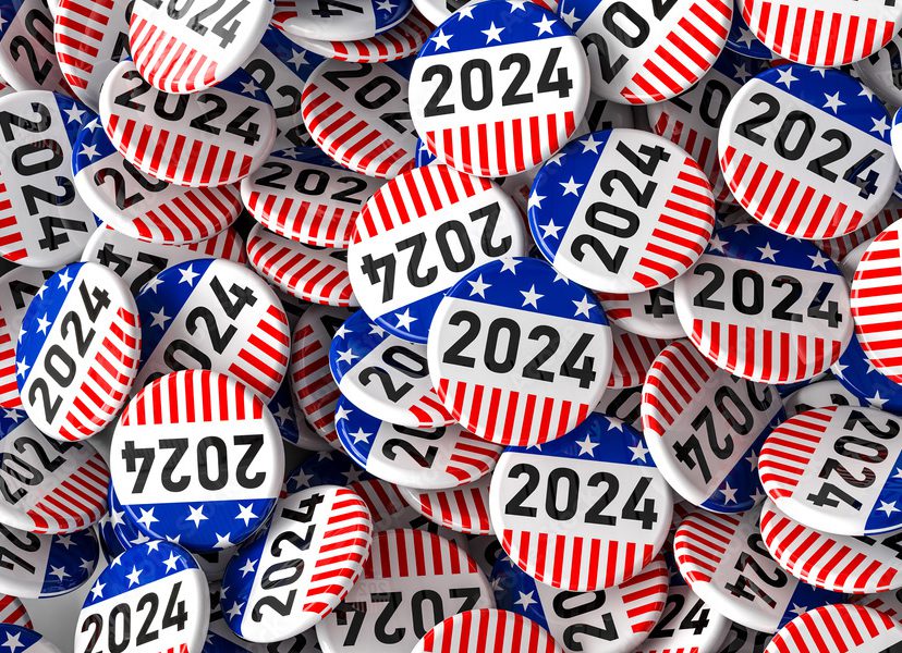 A pile of 2024 election buttons with American flag backdrops.