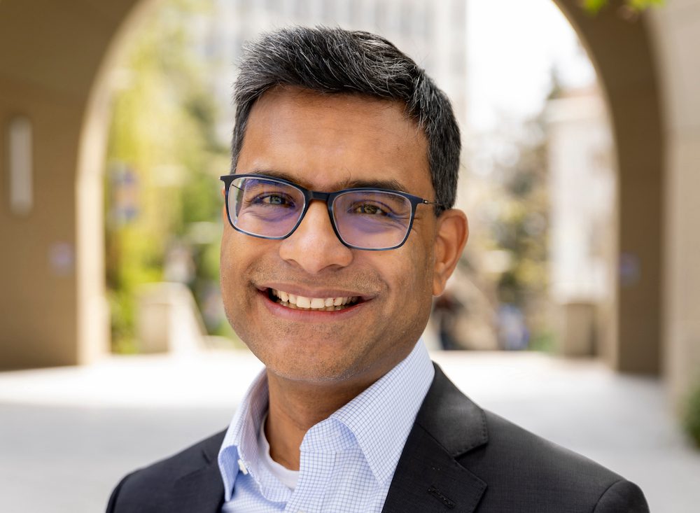 a smiling man wearing a suit on Haas campus