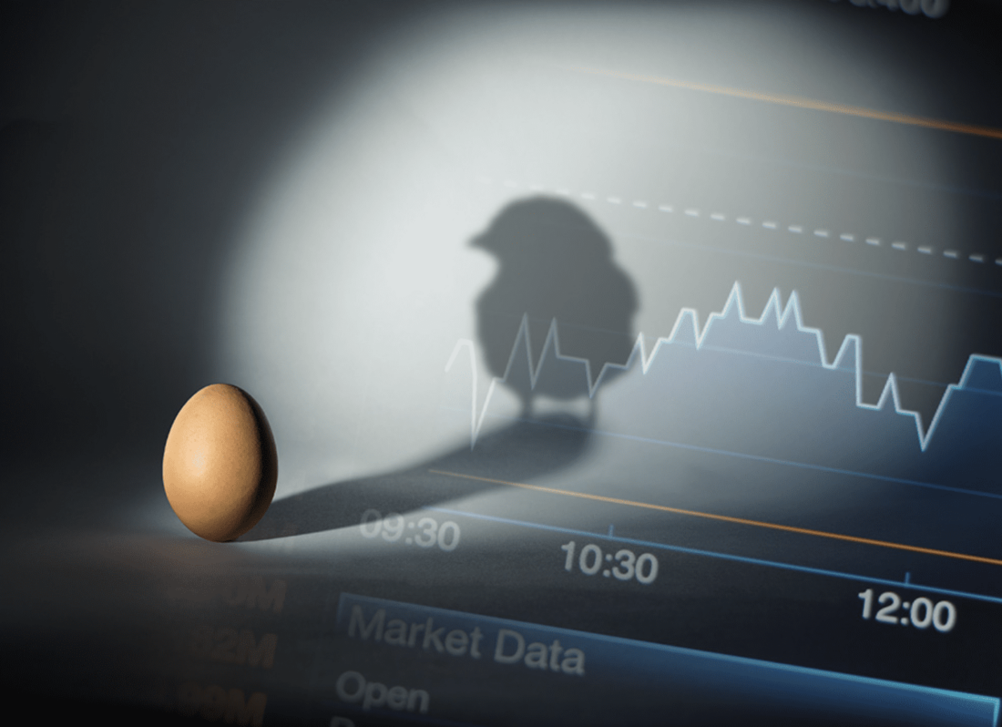 Photo of an egg in the foreground with the shadow of a chicken in the background against a market analysis table graph.