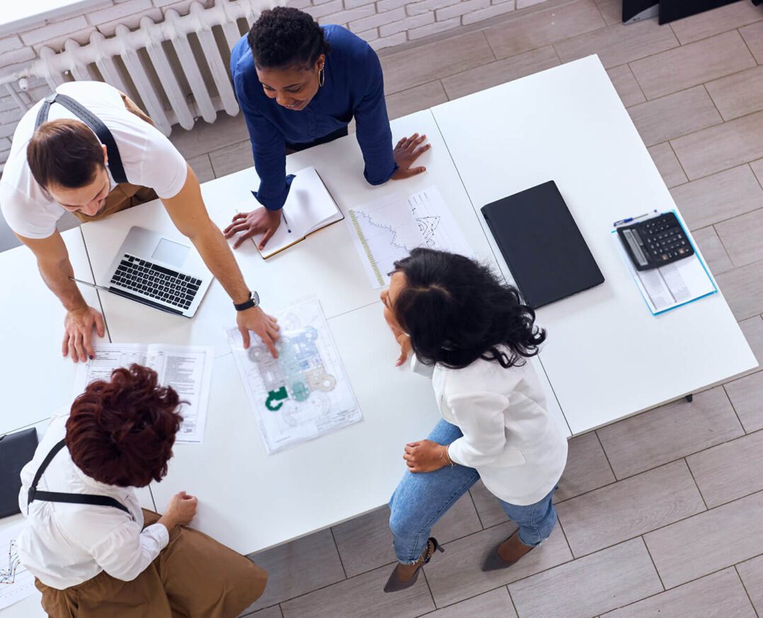 Overhead view of a business team consisting of multiethnic people gathered in a startup office to discuss new project.